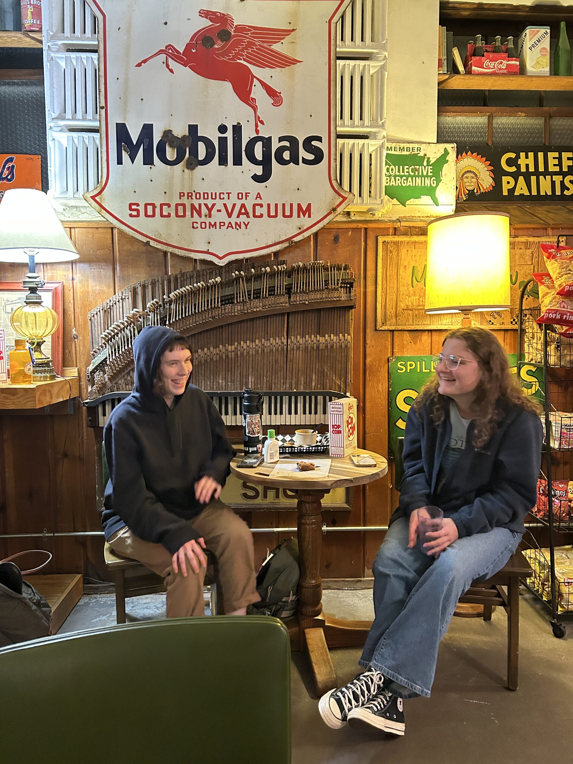 two people sitting at a table talking and laughing