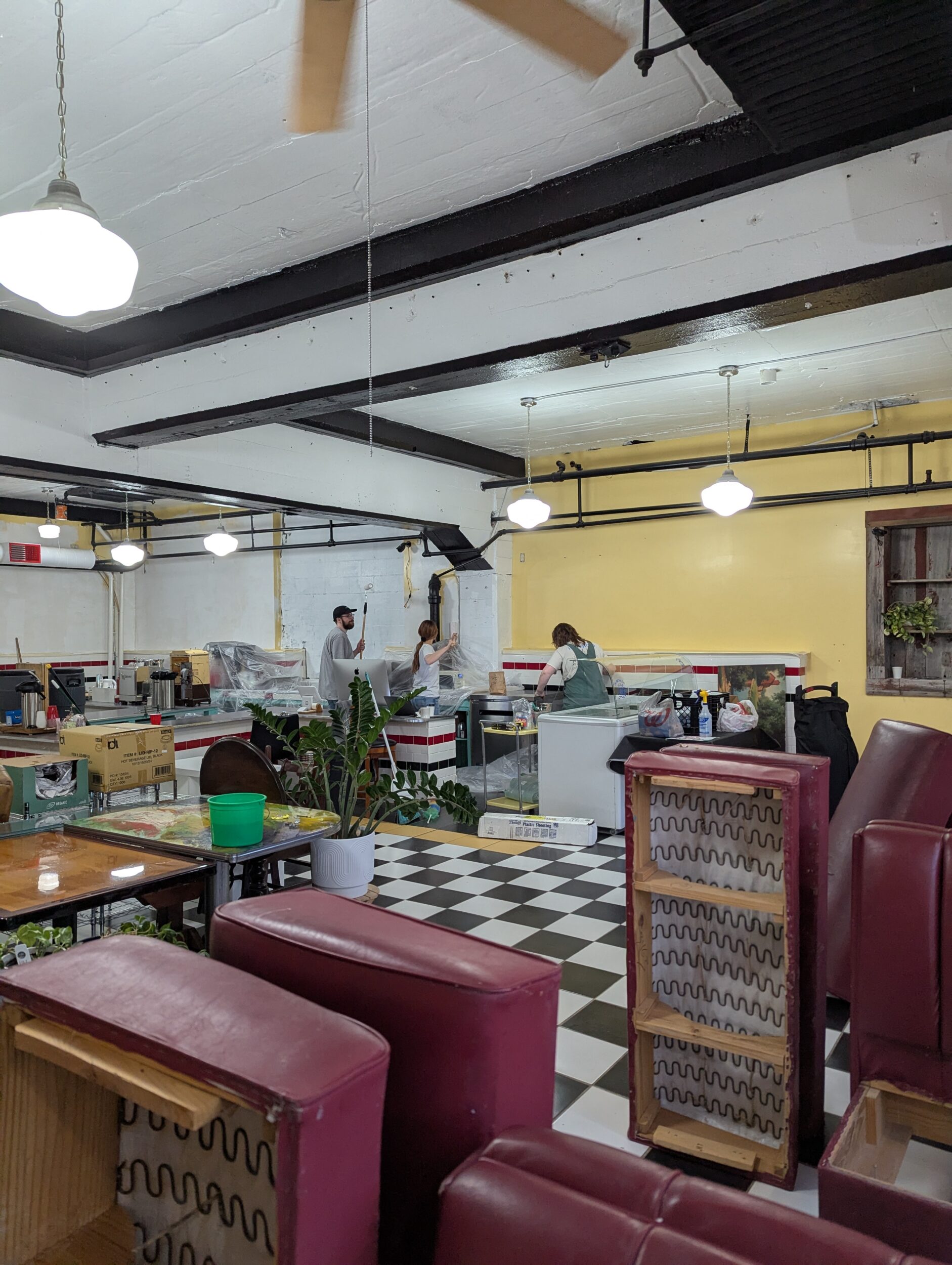 group of people painting walls in a coffee house