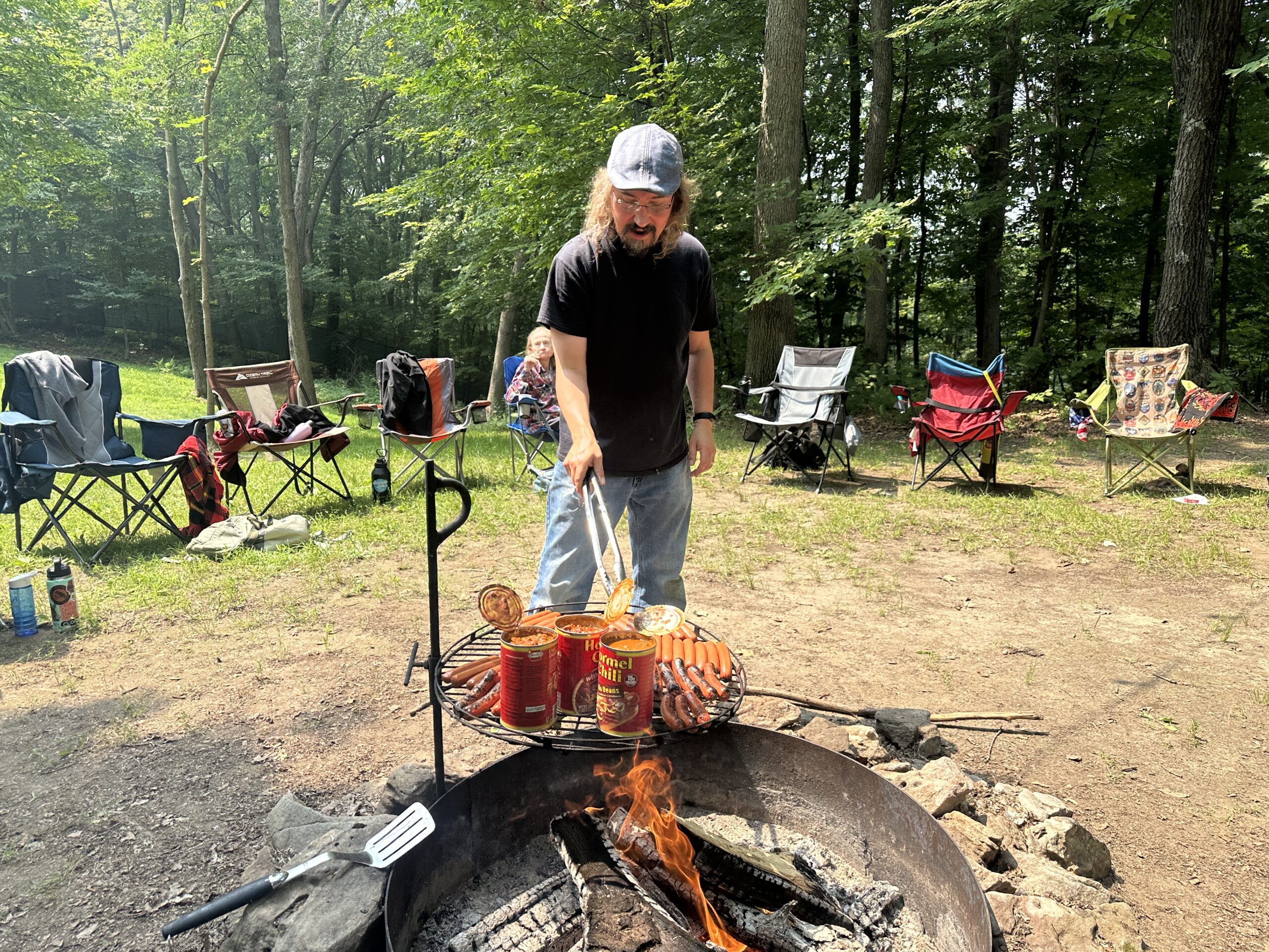 person grilling hotdogs over the fire